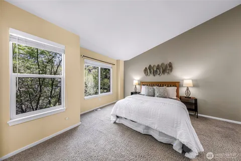 a spacious bedroom with a bed a couch and a window