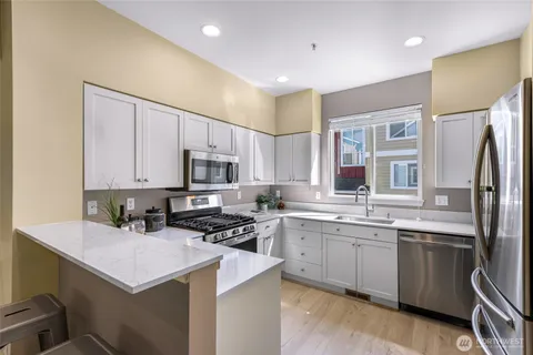 a kitchen with a sink a counter top space stainless steel appliances and cabinets