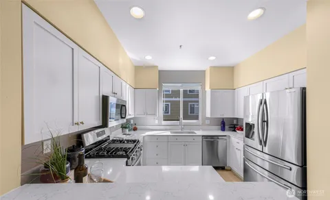 a kitchen with stainless steel appliances a refrigerator sink and microwave