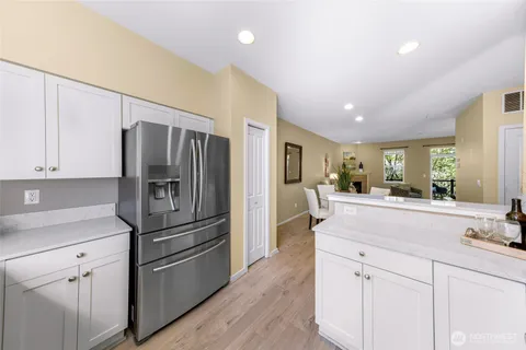 a kitchen with kitchen island white cabinets and stainless steel appliances