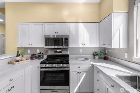 a kitchen with granite countertop a sink a stove and cabinets