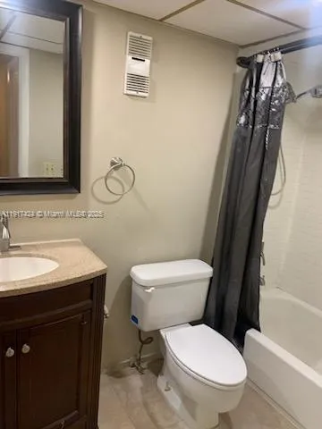 a bathroom with a granite countertop toilet sink and mirror