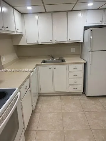 a kitchen with white cabinets and white appliances