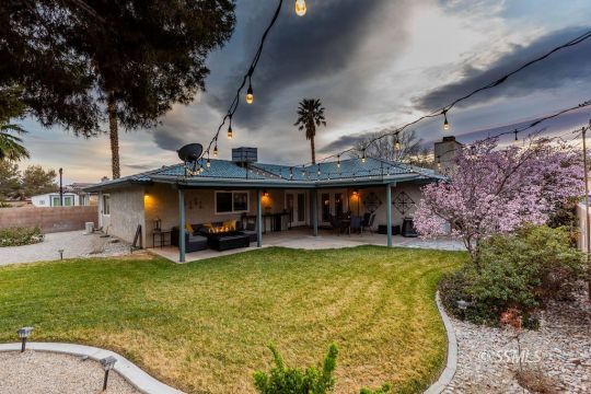 908 North Inyo Street Ridgecrest, CA 93555 - Photo 43 of 46 a view of a swimming pool with lawn chairs and a large tree