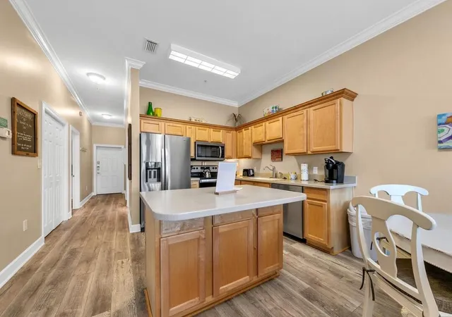 a large kitchen with kitchen island a sink stainless steel appliances and cabinets