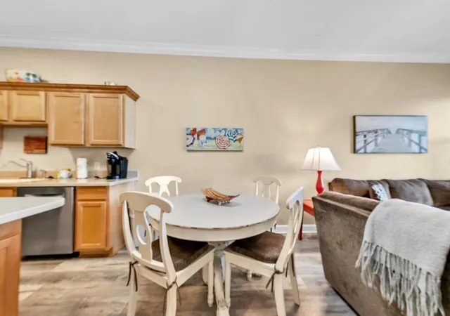 a living room with stainless steel appliances furniture a dining table and chairs