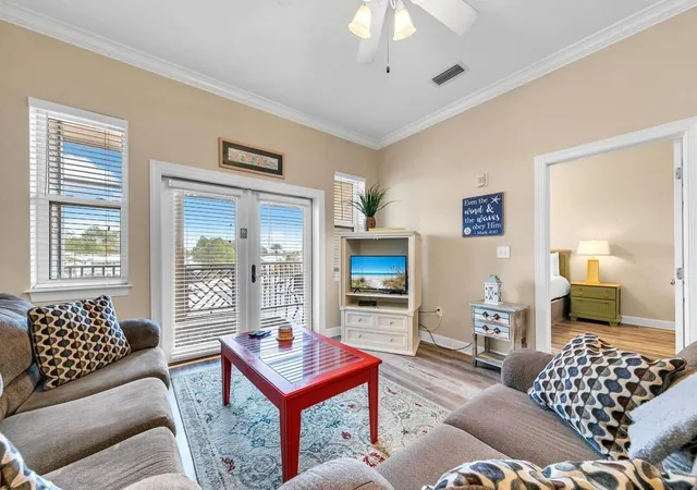 a living room with furniture a flat screen tv and a chandelier