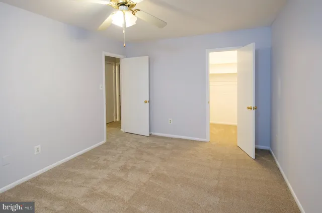 an empty room with chandelier fan