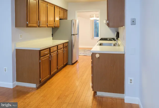 a view of a kitchen with wooden floor and a sink