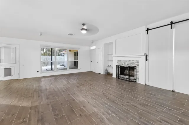 a view of empty room with wooden floor and fireplace