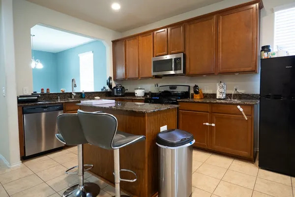 a kitchen with stainless steel appliances granite countertop a stove a sink dishwasher and a refrigerator