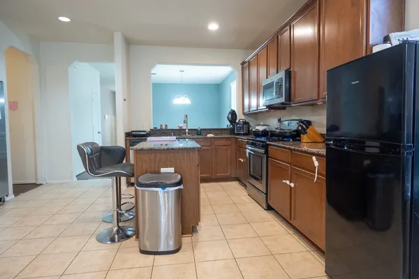 a kitchen with stainless steel appliances granite countertop a stove a sink and a refrigerator