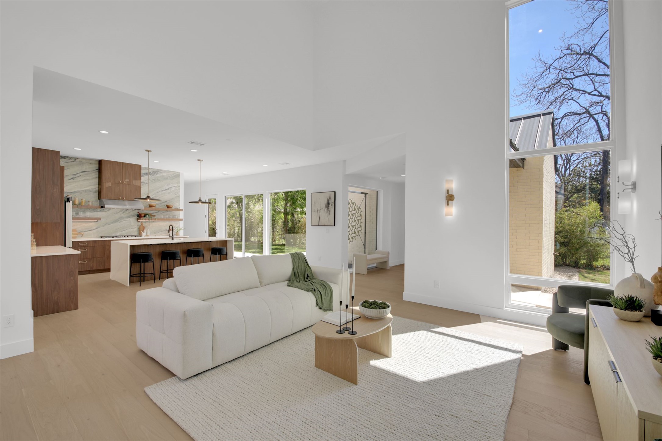 Living area with light wood flooring, recessed lighting, and 24' high ceiling