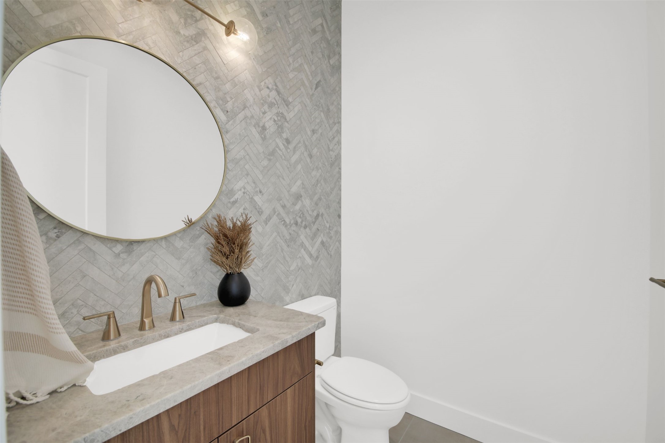 1310 Cullen Avenue Austin, TX 78757 - Photo 20 of 40 half bath/powder room featuring quartz vanity top and tile wall in a chevron pattern