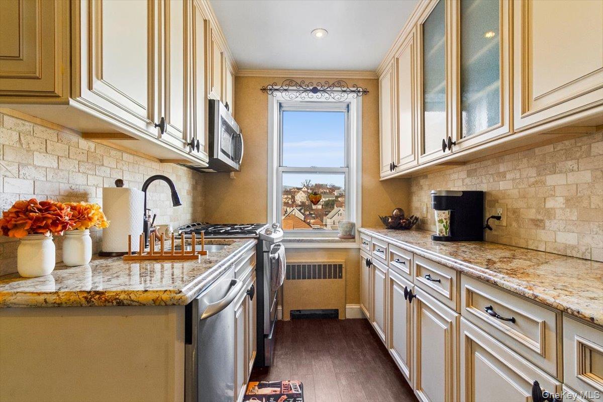 485 Bronx River Road, Unit C62 Yonkers, NY 10704 - Photo 12 of 21 a kitchen with stainless steel appliances granite countertop a sink stove and cabinets