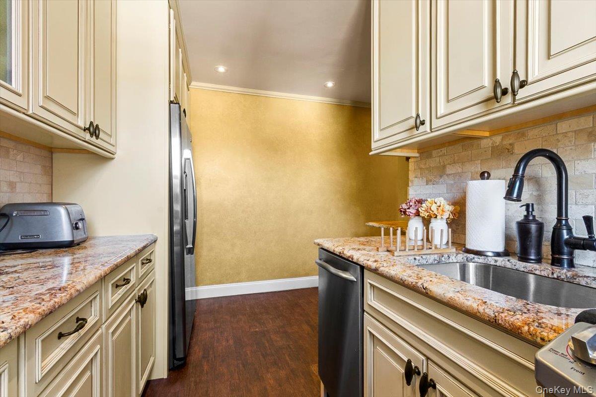 485 Bronx River Road, Unit C62 Yonkers, NY 10704 - Photo 16 of 21 a kitchen with stainless steel appliances granite countertop a sink and cabinets