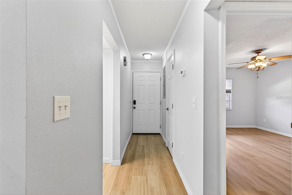 5197 Silent Loop, Unit 124 New Port Richey, FL 34652 - Photo 5 of 55 a view of a hallway with wooden floor and a bathroom