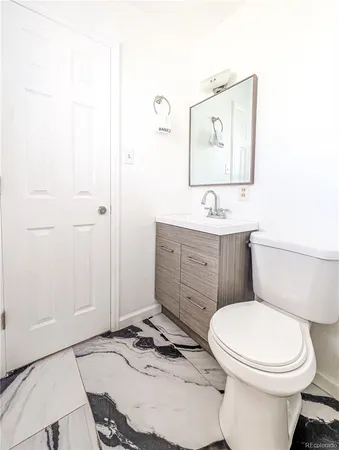 a bathroom with a toilet a sink and mirror