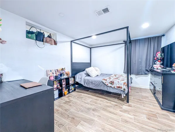 a bedroom with bed and wooden floor