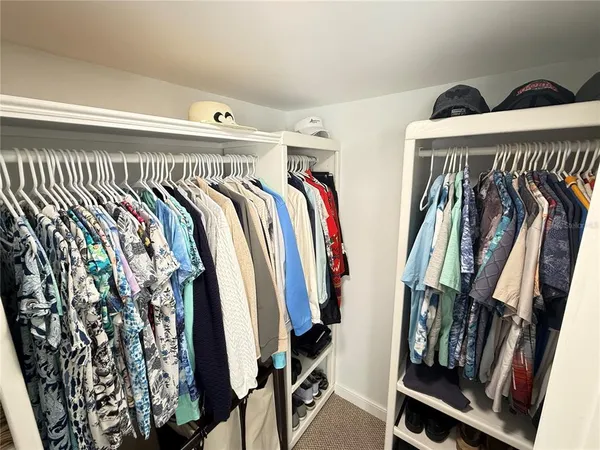 a view of walk in closet with clothes and shoes