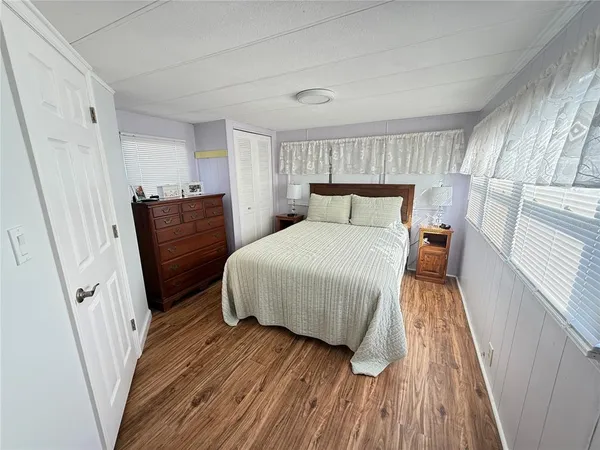 a bedroom with a bed and wooden floor