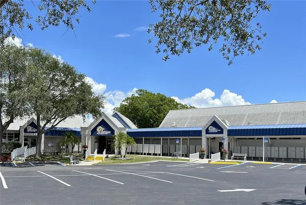 a front view of a building with streets and trees