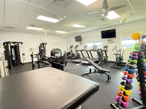 a room with gym equipment and a flat screen tv