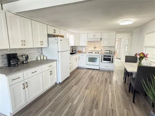 a kitchen with granite countertop white cabinets and white appliances