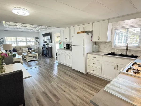a kitchen with white cabinets and black appliances