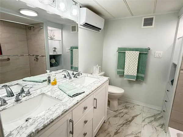 a bathroom with a granite countertop sink a toilet and a mirror