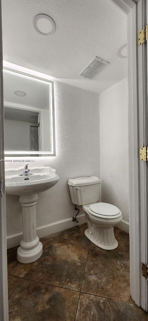 1621 Collins Avenue, Unit 404 Miami Beach, FL 33139 - Photo 10 of 26 a bathroom with a toilet sink and mirror