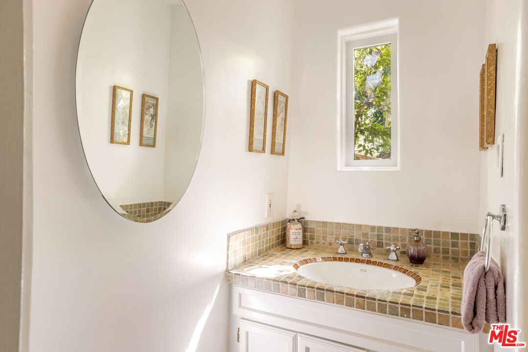 21714 Encina Road Topanga, CA 90290 - Photo 20 of 45 a bathroom with a granite countertop sink and a mirror