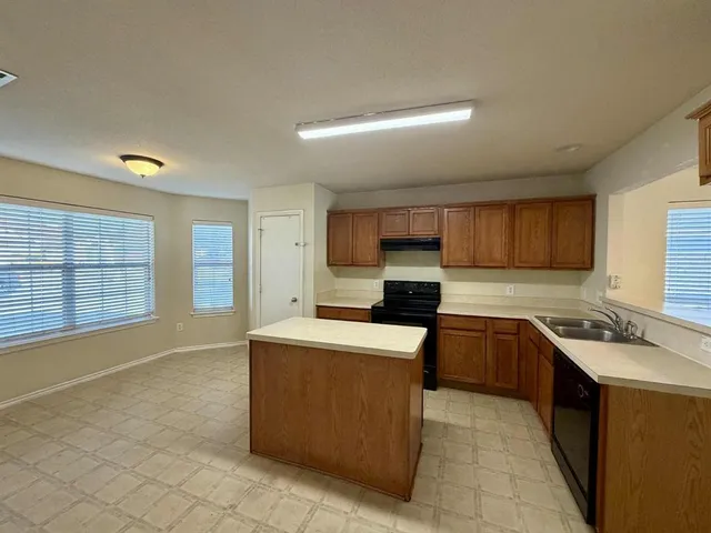 a large kitchen with kitchen island a sink stainless steel appliances and cabinets