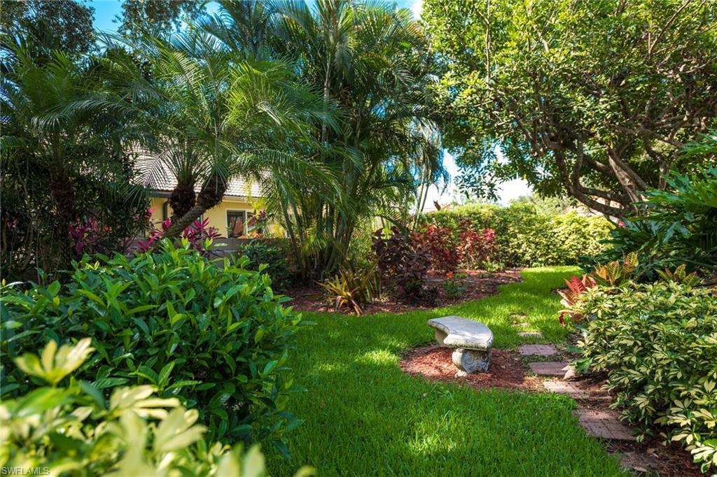 172 Napa Ridge Way Naples, FL 34119 - Photo 3 of 17 a view of a garden with plants and large trees