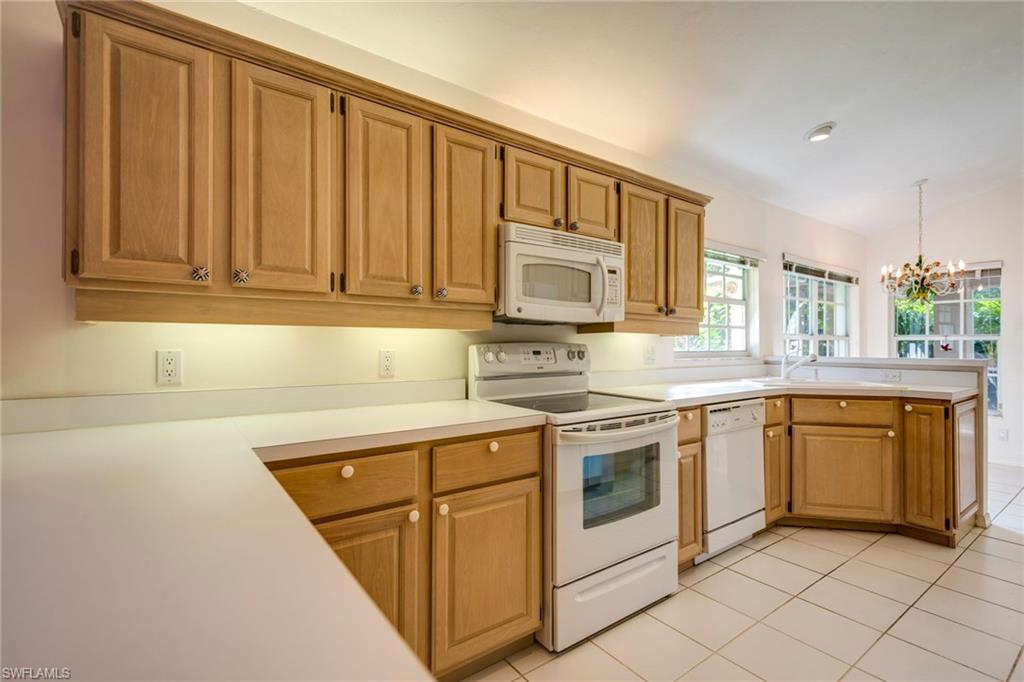 172 Napa Ridge Way Naples, FL 34119 - Photo 6 of 17 a kitchen with stainless steel appliances granite countertop a stove a sink and a microwave