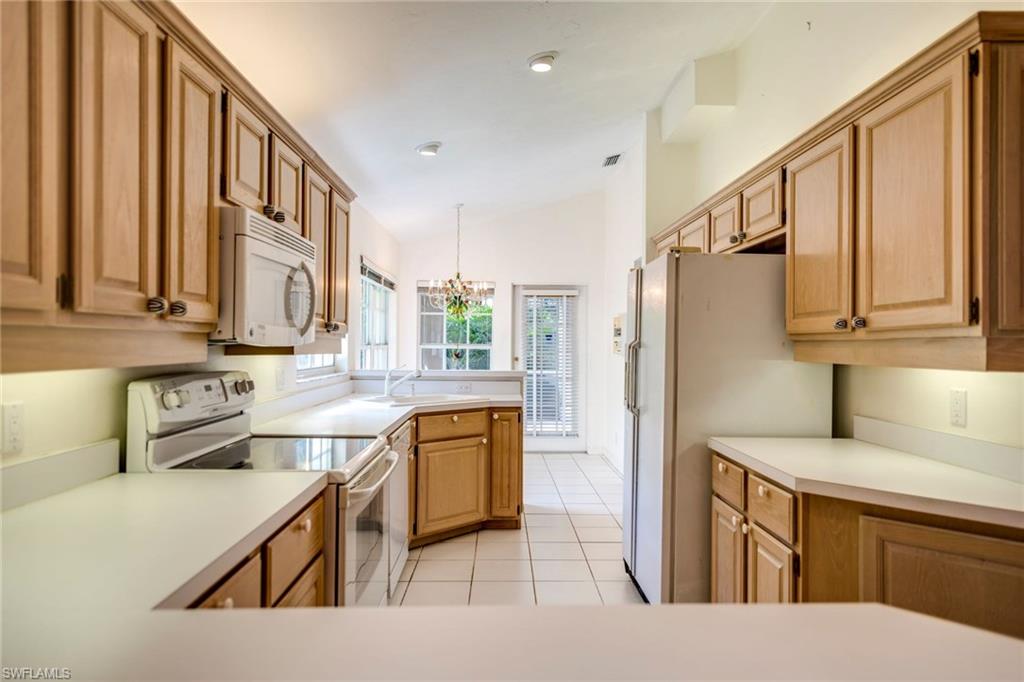 172 Napa Ridge Way Naples, FL 34119 - Photo 7 of 17 a kitchen with stainless steel appliances granite countertop a refrigerator a stove top oven a sink and dishwasher