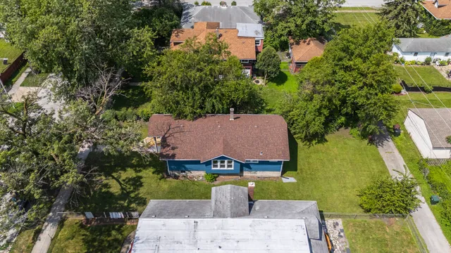 an aerial view of a house with garden space and swimming pool
