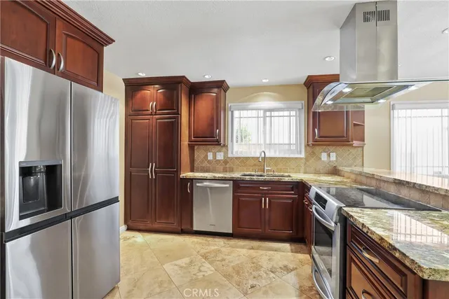 a kitchen with stainless steel appliances granite countertop a sink stove and refrigerator
