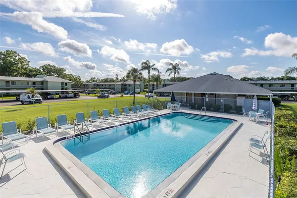 a view of a swimming pool with lawn chairs