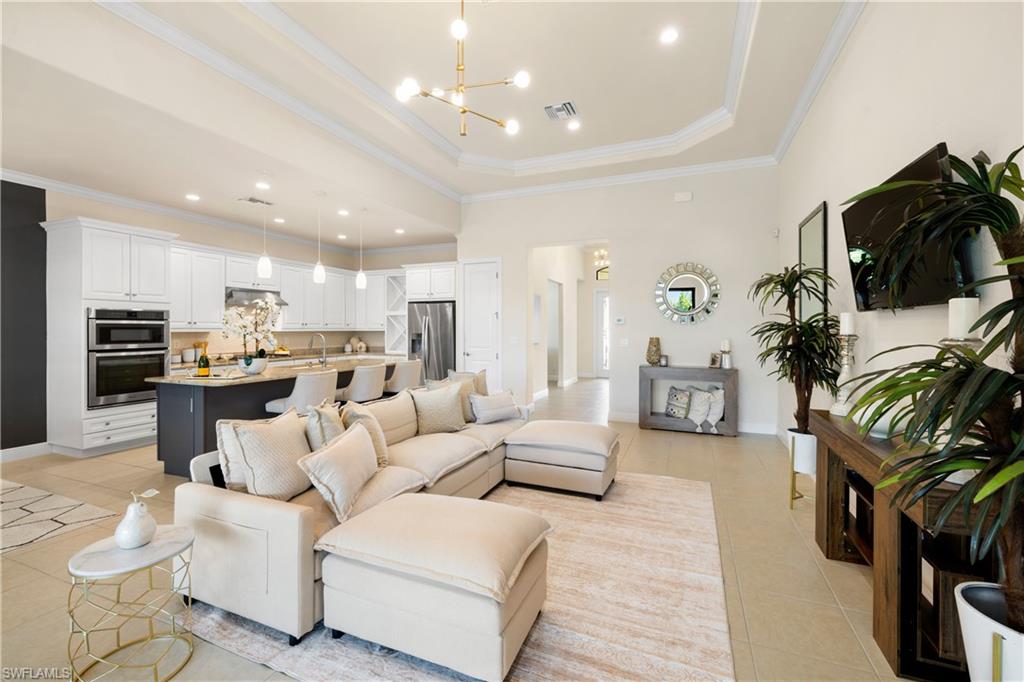 10137 Florence Circle Naples, FL 34119 - Photo 13 of 42 a living room with furniture and a flat screen tv
