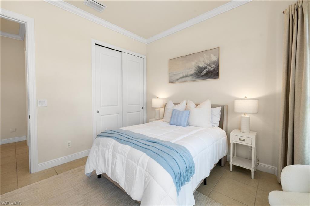 10137 Florence Circle Naples, FL 34119 - Photo 22 of 42 a bedroom with a bed and a painting on the wall