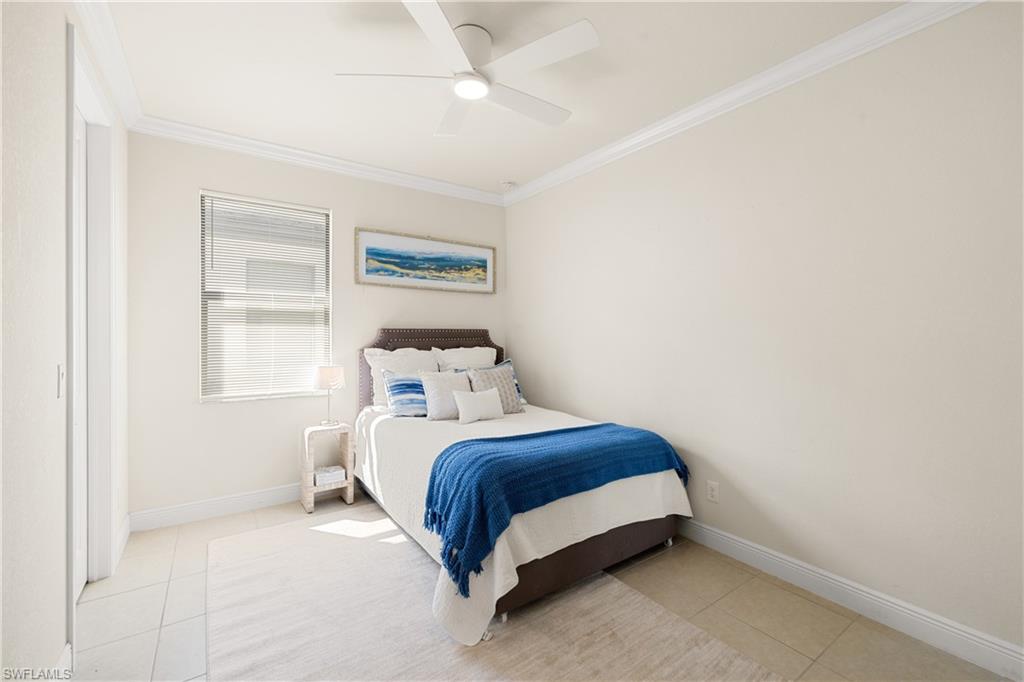 10137 Florence Circle Naples, FL 34119 - Photo 24 of 42 a bedroom with a bed lamp and a window