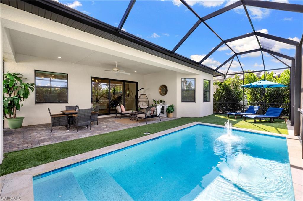 10137 Florence Circle Naples, FL 34119 - Photo 31 of 42 a view of swimming pool with lawn chairs under an umbrella