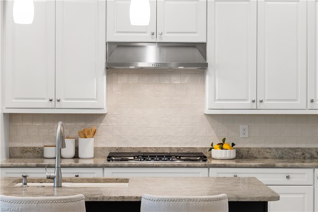 10137 Florence Circle Naples, FL 34119 - Photo 32 of 42 a kitchen with granite countertop white cabinets and a stainless steel appliances