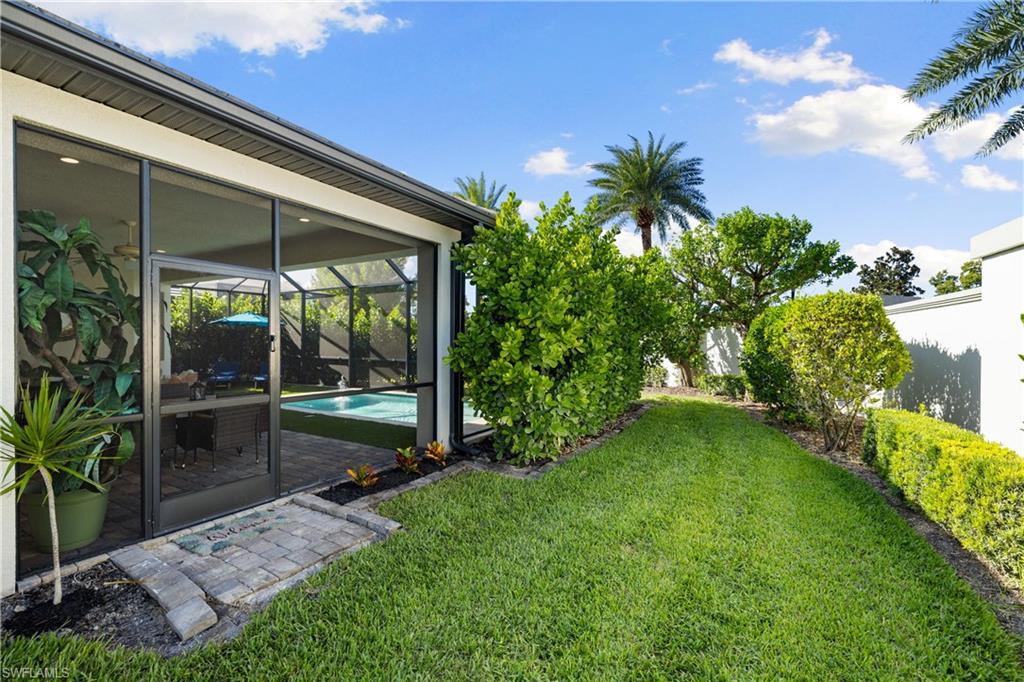 10137 Florence Circle Naples, FL 34119 - Photo 37 of 42 a backyard of a house with table and chairs plants and large tree