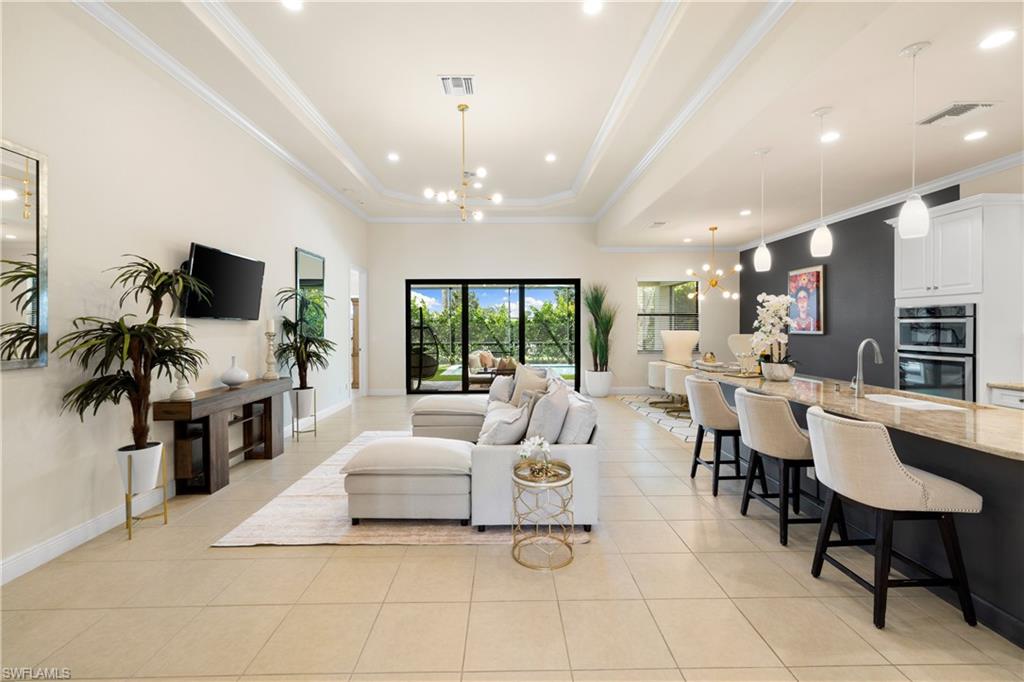 10137 Florence Circle Naples, FL 34119 - Photo 4 of 42 a living room with furniture a flat screen tv and a large window