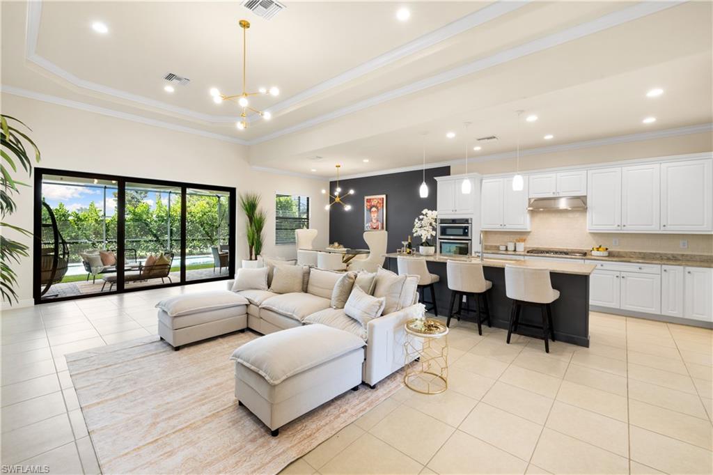 10137 Florence Circle Naples, FL 34119 - Photo 6 of 42 a living room with couches chairs kitchen view and kitchen view