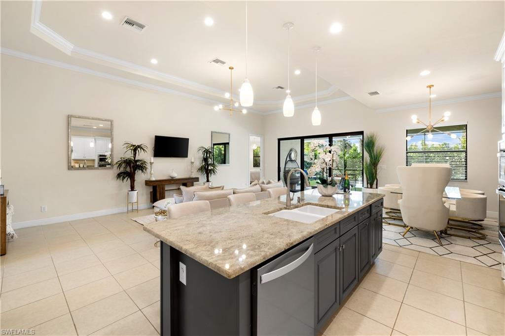 10137 Florence Circle Naples, FL 34119 - Photo 8 of 42 a dining hall with stainless steel appliances kitchen island granite countertop a granite counter tops and white cabinets
