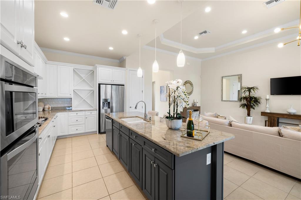 10137 Florence Circle Naples, FL 34119 - Photo 9 of 42 a large kitchen with kitchen island a sink a counter top stainless steel appliances and cabinets