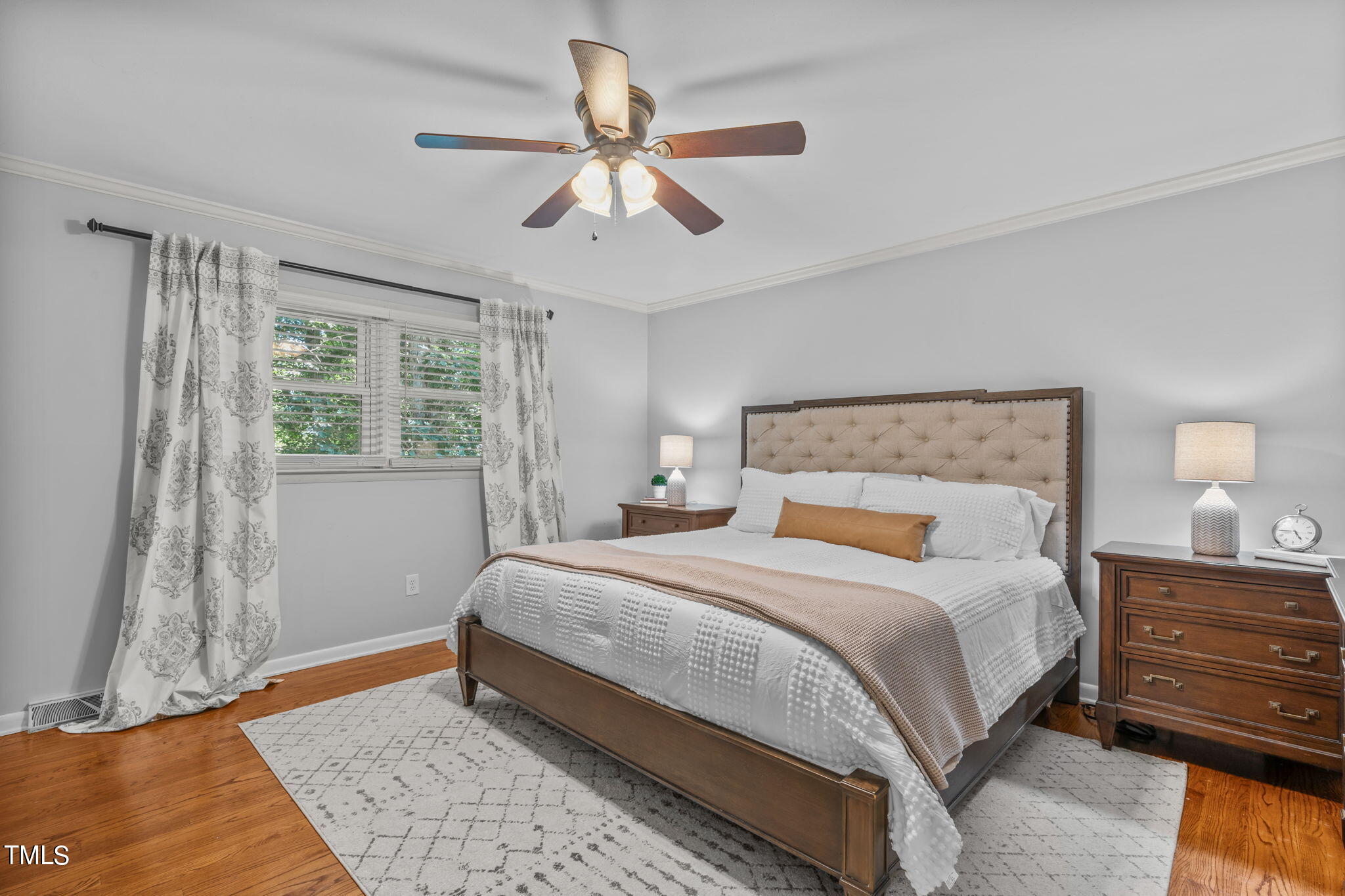 517 Compton Road Raleigh, NC 27609 - Photo 21 of 51 a bedroom with a large bed and a chandelier
